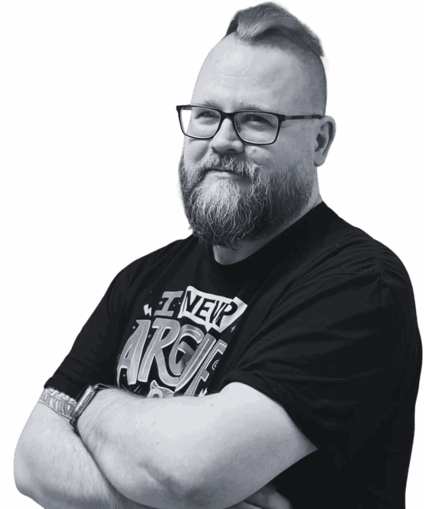 Mann mit Brille und Bart lächelt verschmitzt.